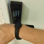 Manilla inteligente utilizada para desbloquear una cerradura digital con teclado iluminado en la puerta.