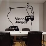 Espacio de coworking y entretenimiento con mesas, sillas y una pared de graffiti moderno.